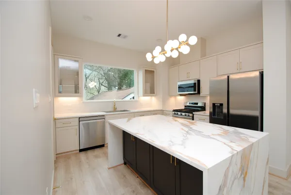 a kitchen with stainless steel appliances a stove refrigerator and microwave