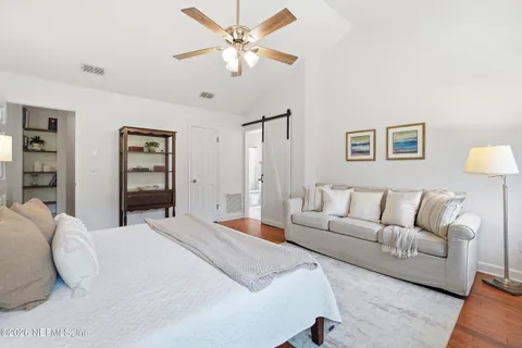 a spacious bedroom with a bed a couch and a chandelier