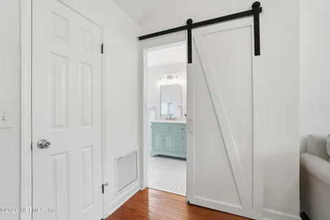 a walk in closet with wooden floor