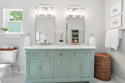 a bathroom with a granite countertop double vanity sink mirror and