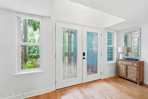 an empty room with wooden floor and windows