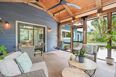 a living room with patio furniture and a potted plant