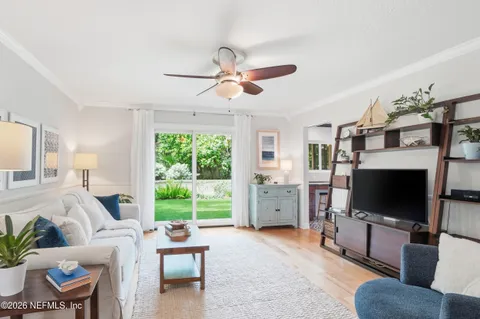 a living room with furniture a flat screen tv and a large window