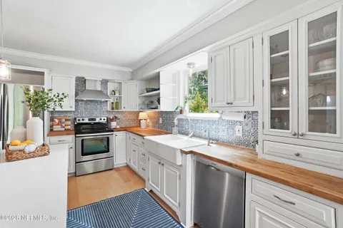 a kitchen with granite countertop a sink a counter space appliances and cabinets