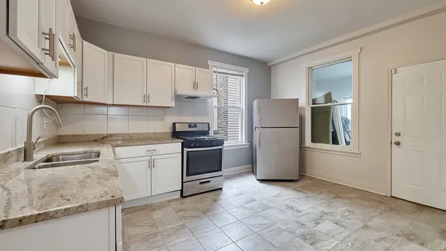 a kitchen with a refrigerator sink and cabinets