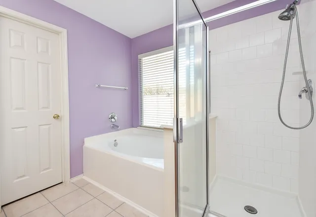 a bathroom with a bathtub a shower and a shower