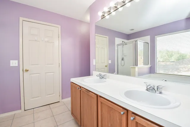 a bathroom with a sink vanity granite tub shower and a mirror