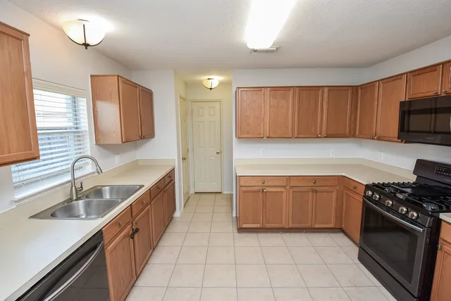 a kitchen with stainless steel appliances granite countertop a sink stove and cabinets