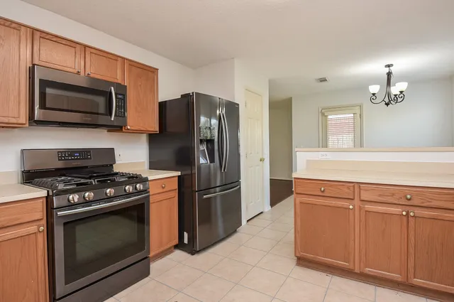 a kitchen with cabinets stainless steel appliances and a counter space