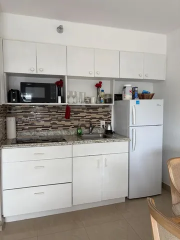 a kitchen with appliances a microwave and cabinets