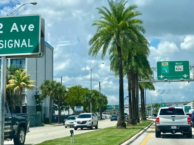 a car parked in front of a brick house with a small yard