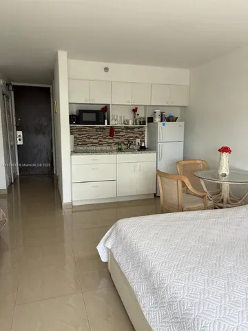 a bedroom with a bed and a view of living room