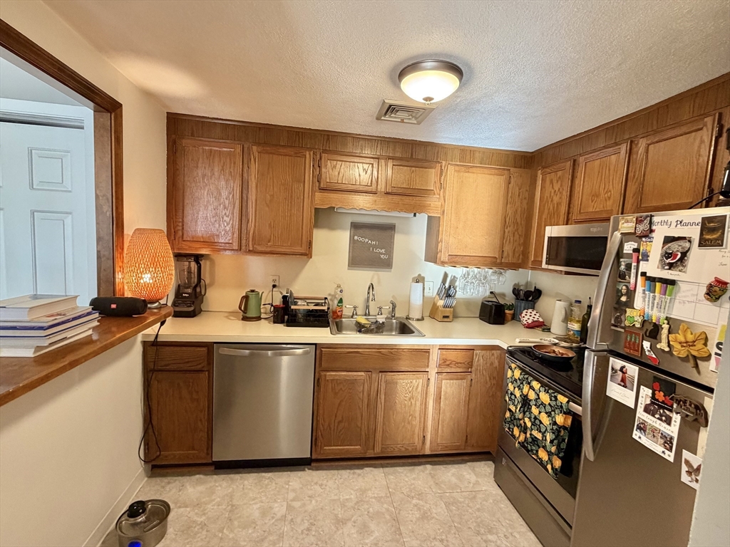 136 Central Street, Unit C 6 Hudson, MA 01749 - Photo 1 of 20 a kitchen with stainless steel appliances a sink a stove a refrigerator cabinets and a window