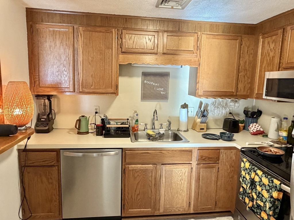 136 Central Street, Unit C 6 Hudson, MA 01749 - Photo 14 of 20 a kitchen with stainless steel appliances granite countertop a sink stove refrigerator and cabinets