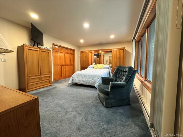 a living room with furniture a flat screen tv and a refrigerator