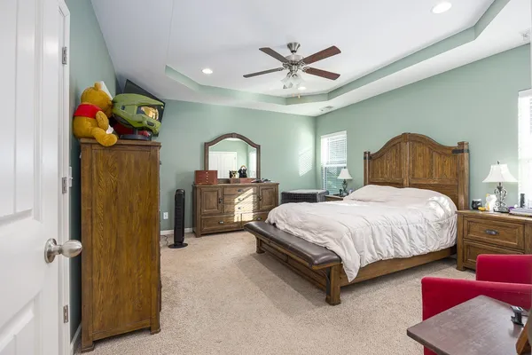 a bedroom with a bed dresser and a window