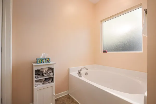 a bathroom with a bathtub and a window