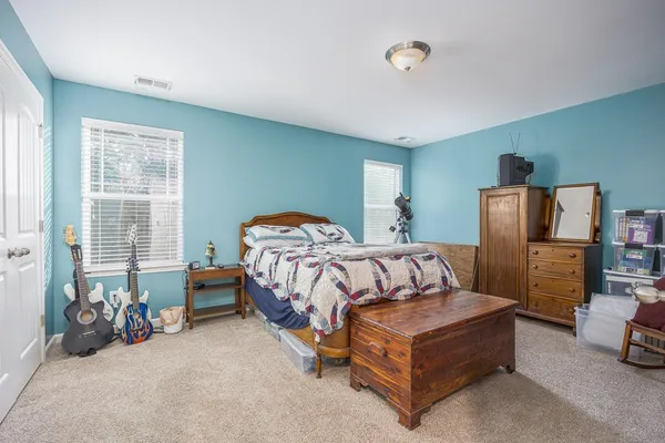 a bed room with a bed and a chair