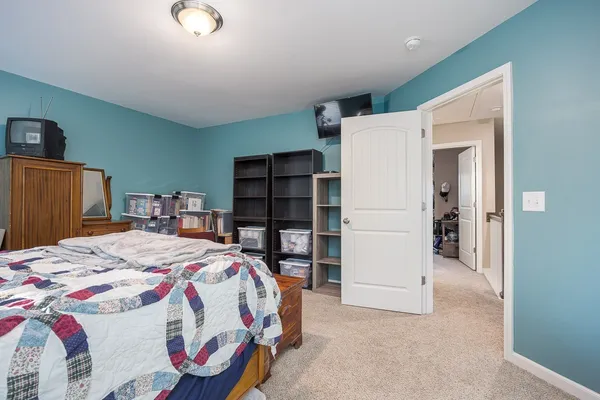 a bed sitting in a bedroom and kitchen view