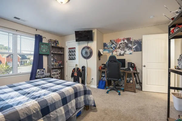 a bed sitting in a bedroom next to a window