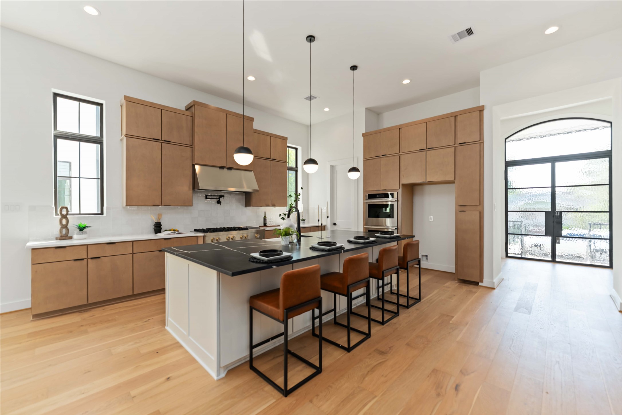 615 Wendel Street Houston, TX 77009 - Photo 5 of 21 a kitchen with stainless steel appliances granite countertop a stove a sink a refrigerator and white cabinets with wooden floor