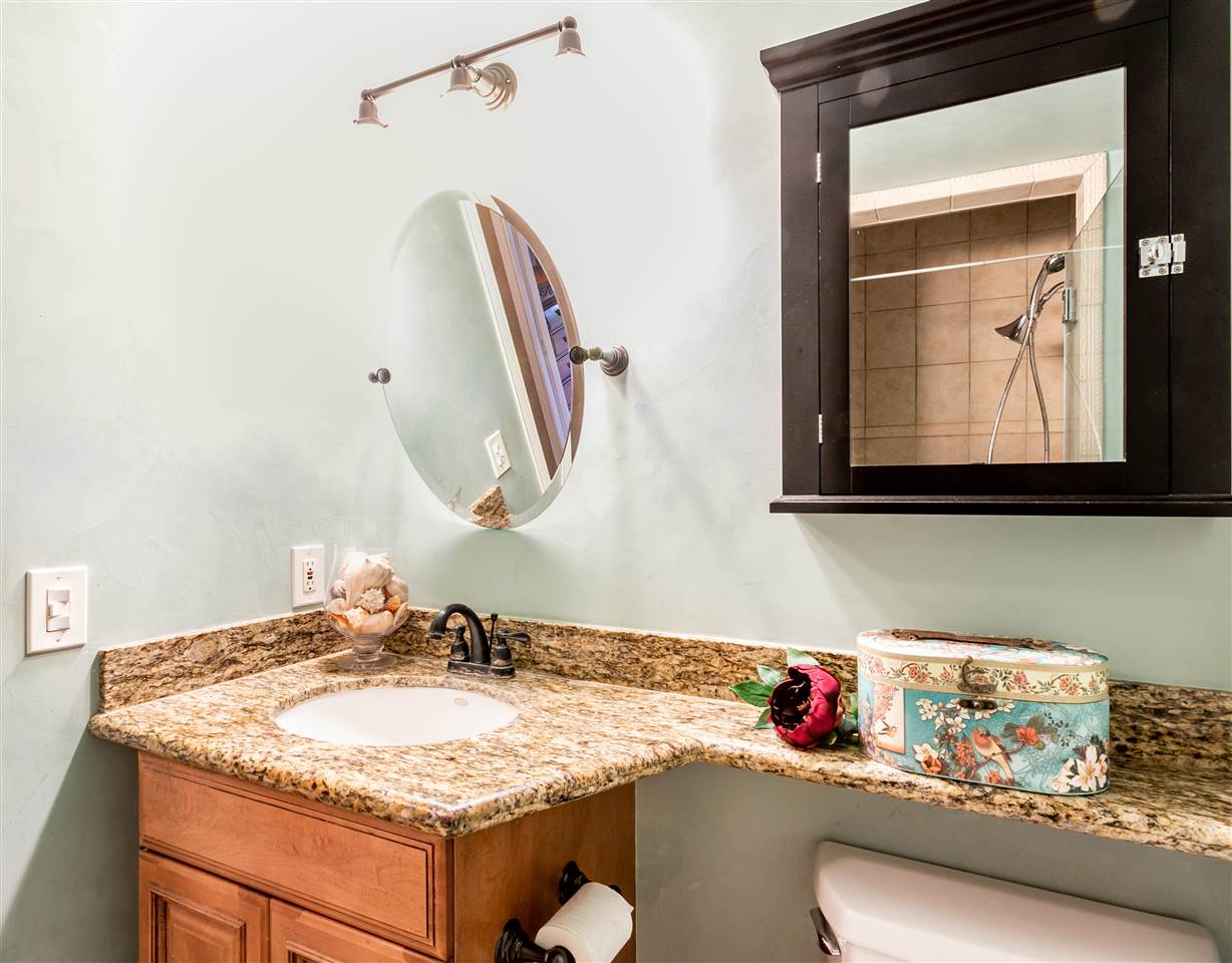 140 Uwapo Road, Unit 6101 Kihei, HI 96753 - Photo 18 of 30 a bathroom with a granite countertop sink and a mirror