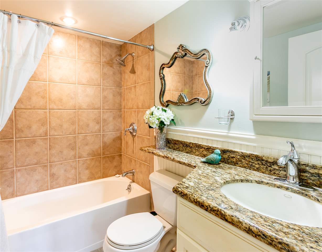 140 Uwapo Road, Unit 6101 Kihei, HI 96753 - Photo 23 of 30 a bathroom with a granite countertop sink and a mirror