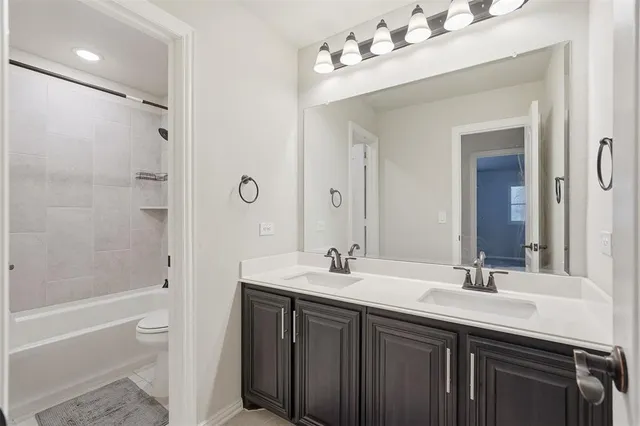 a bathroom with a double vanity sink mirror double and bathtub