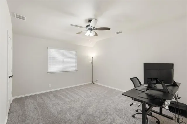 a view of a workspace with furniture and a window