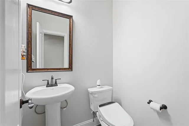 a bathroom with a sink a toilet and mirror