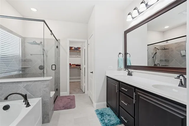 a spacious bathroom with a tub sink double vanity and shower