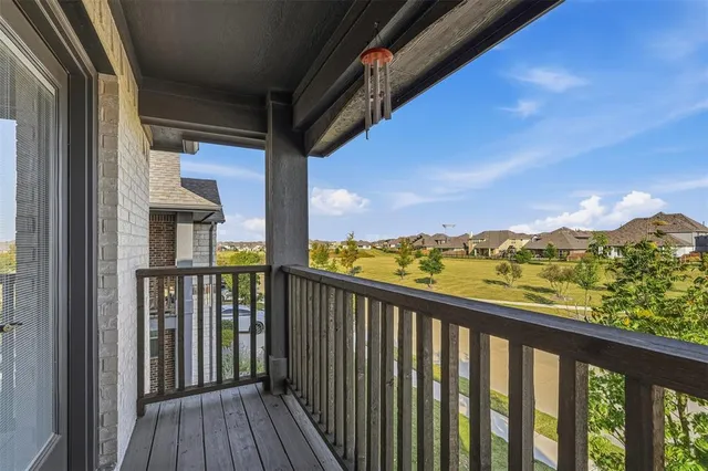 a view of a balcony with wooden floor & fence