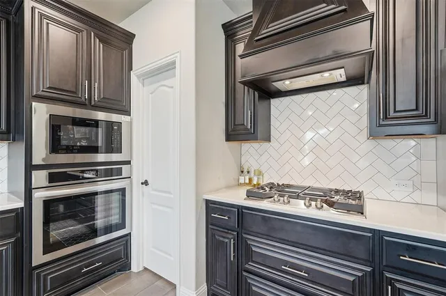 a kitchen with granite countertop cabinets stainless steel appliances and wooden floor