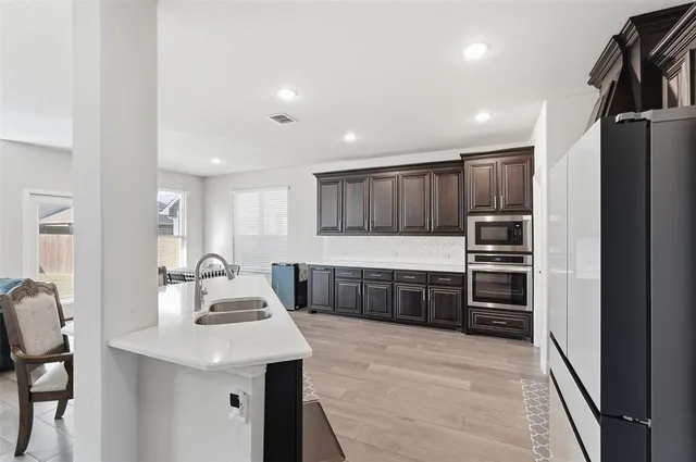 a kitchen with stainless steel appliances kitchen island granite countertop a refrigerator and a stove top oven
