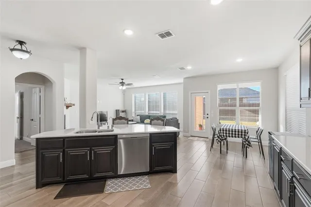 a living room with stainless steel appliances granite countertop furniture a fireplace and a large window