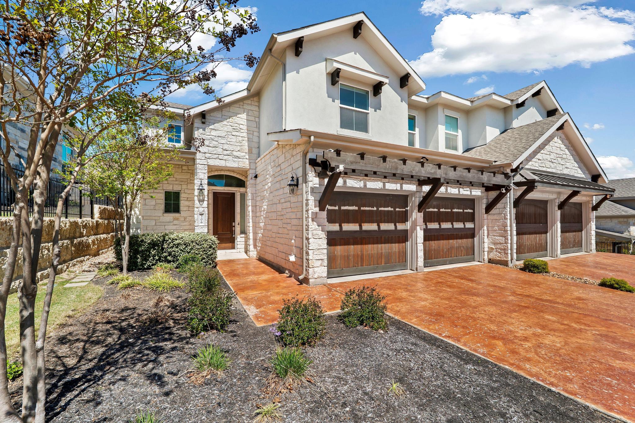 306 Cartwheel Bend, Unit 130 Austin, TX 78738 - Photo 17 of 40 a front view of a house with a yard and garage
