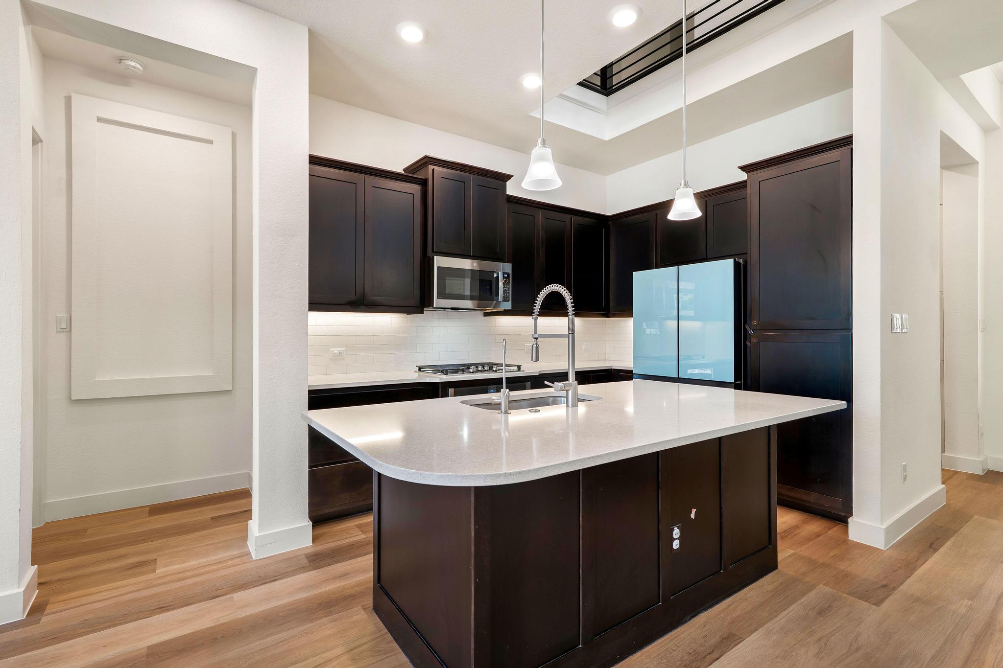 306 Cartwheel Bend, Unit 130 Austin, TX 78738 - Photo 25 of 40 a kitchen with stainless steel appliances granite countertop a sink and a refrigerator