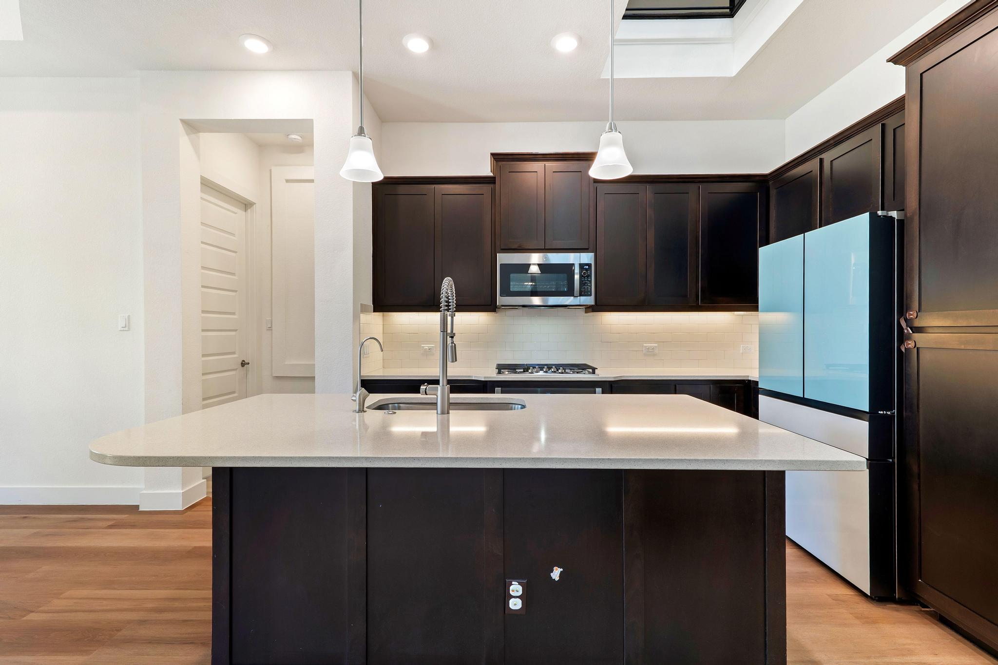 306 Cartwheel Bend, Unit 130 Austin, TX 78738 - Photo 26 of 40 a kitchen with kitchen island a counter top space cabinets and stainless steel appliances