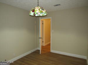 6662 Goodall Mill Road Macon, GA 31216 - Photo 31 of 50 an empty room with wooden floor and chandelier