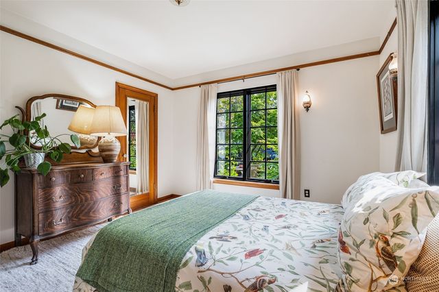 a bedroom with a bed dresser and a window