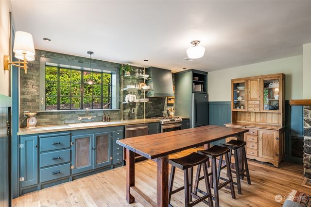 a kitchen with granite countertop a table and chairs in it