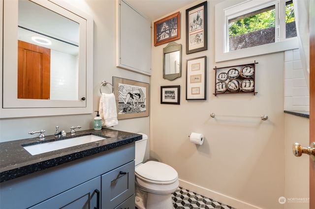 a bathroom with a granite countertop sink mirror and toilet