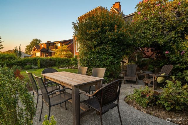 a patio with table and chairs and potted plants