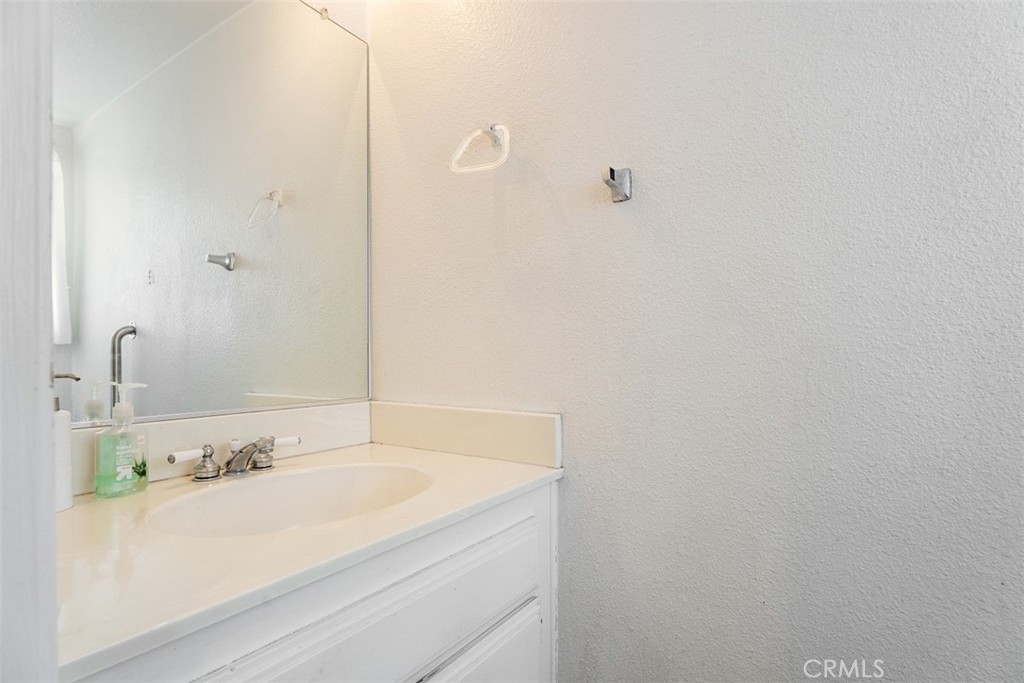 7040 Marino Place Rancho Cucamonga, CA 91701 - Photo 15 of 45 a bathroom with a granite countertop sink and mirror