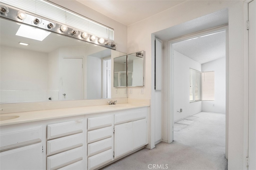 7040 Marino Place Rancho Cucamonga, CA 91701 - Photo 20 of 45 a spacious bathroom with a shower a sink and mirror
