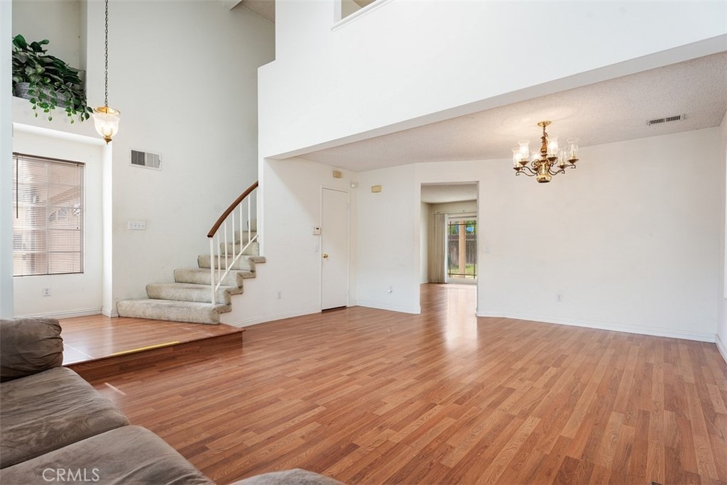 7040 Marino Place Rancho Cucamonga, CA 91701 - Photo 8 of 45 a view of an empty room with wooden floor and a potted plant