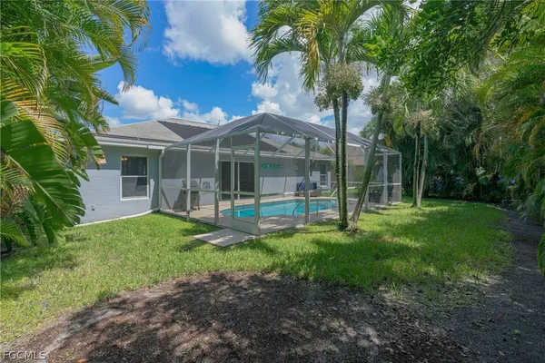 a view of a house with backyard and a tree