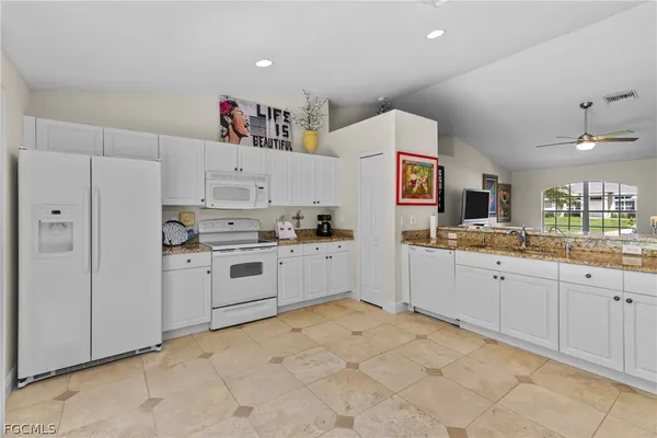 a kitchen with white cabinets and white appliances