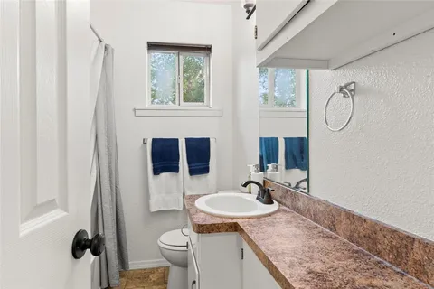 a bathroom with a granite countertop sink toilet and shower