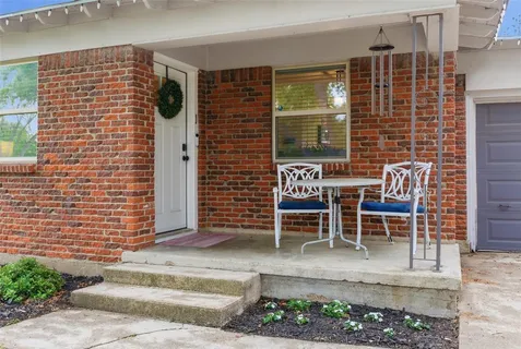 a brick building with a bench and a potted plant